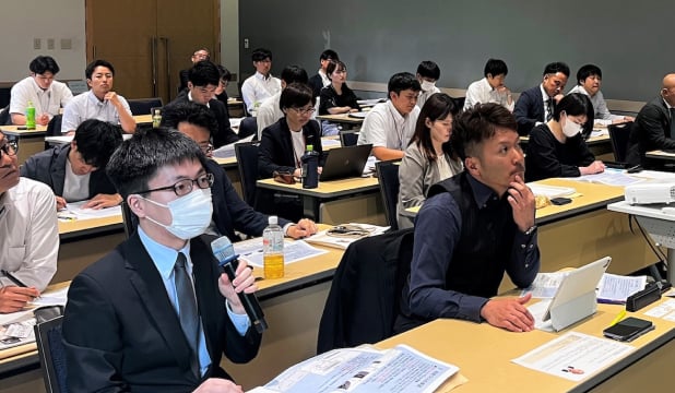 会場で講義を受け、意見を交わす受講生